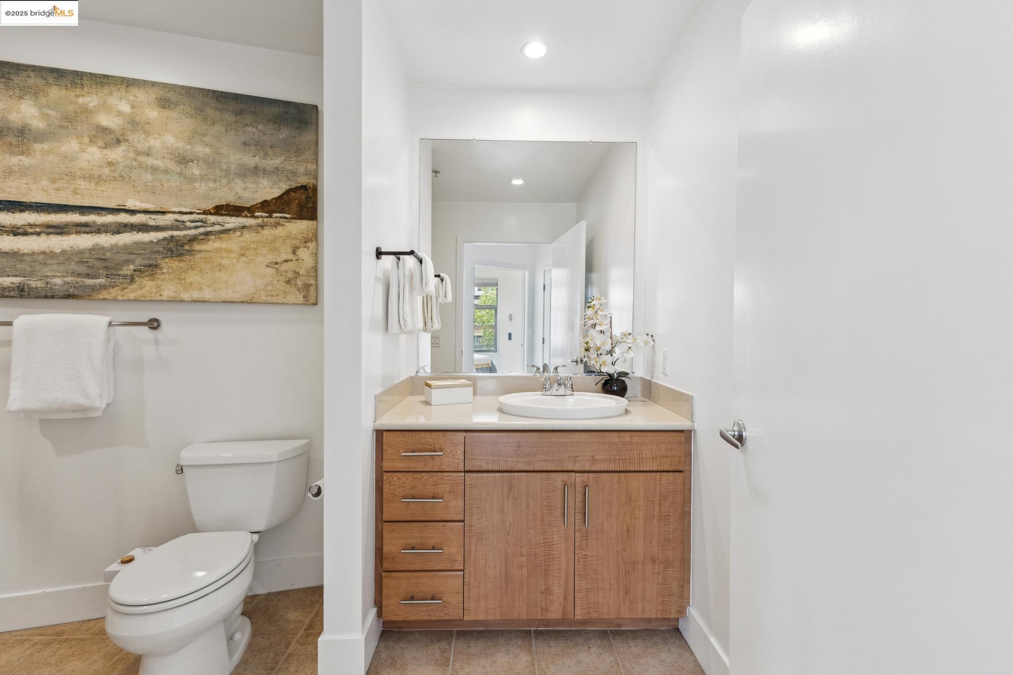 438 West Grand Avenue, Unit 420 Oakland, CA 94612 - Photo 38 of 58 a bathroom with a granite countertop toilet sink and mirror