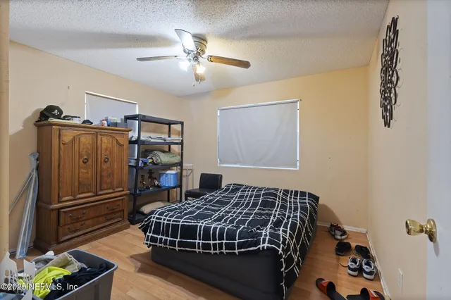 a bedroom with a bed and wooden floor