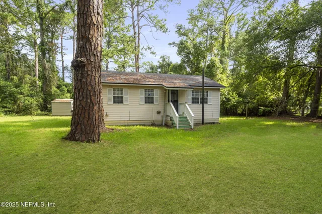 a view of a house with backyard and garden