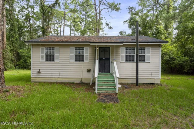 a view of a house with a backyard