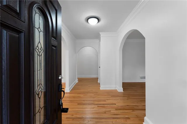 a view of empty room with wooden floor