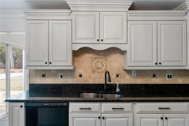 a kitchen with stainless steel appliances granite countertop white cabinets and a granite counter tops