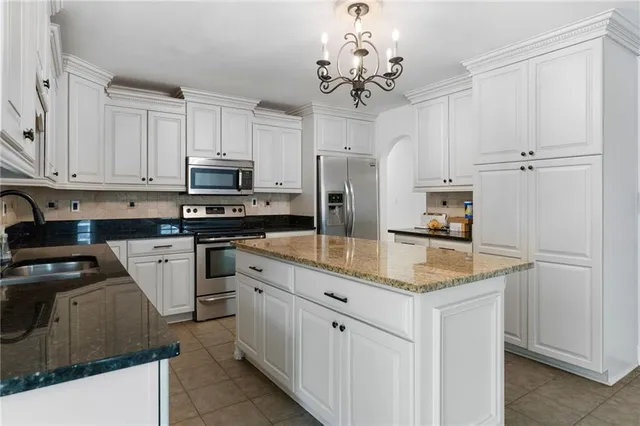 a kitchen with white cabinets and refrigerator