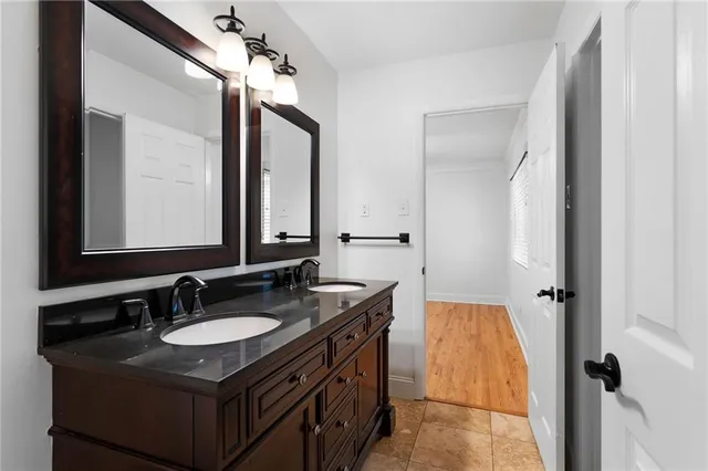a bathroom with a granite countertop sink a mirror and a shower