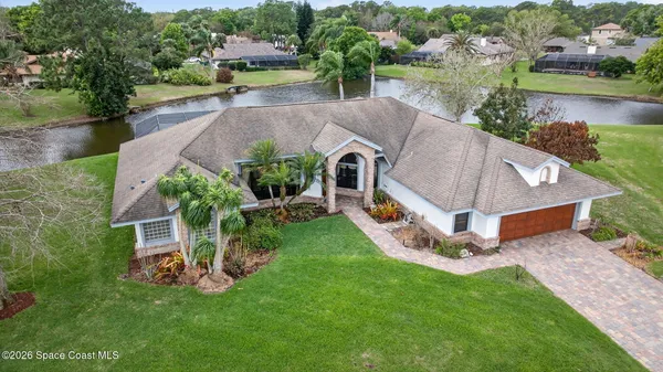 an aerial view of a house with a garden and lake view