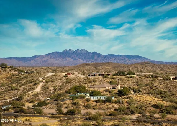 a view of a dry yard with mountains in the background