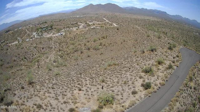 a view of a dry yard with mountains in the background
