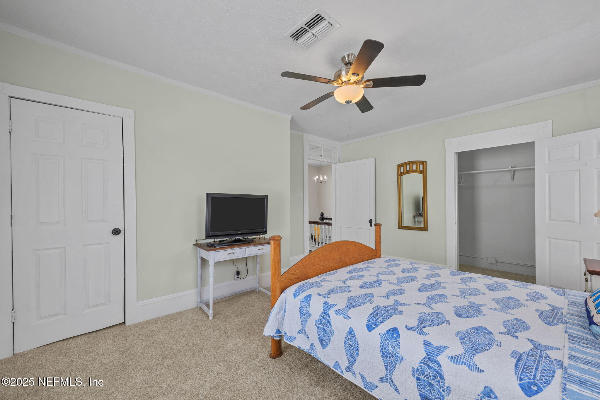 313 Madison Street Palatka, FL 32177 - Photo 21 of 38 a bedroom with a bed and a chandelier