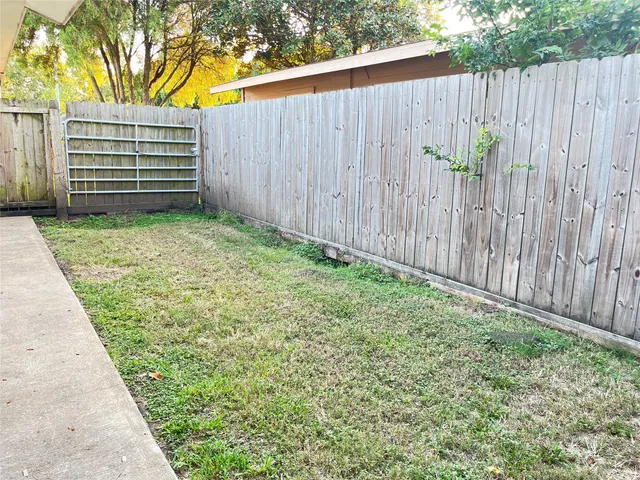 a view of a backyard with wooden fence
