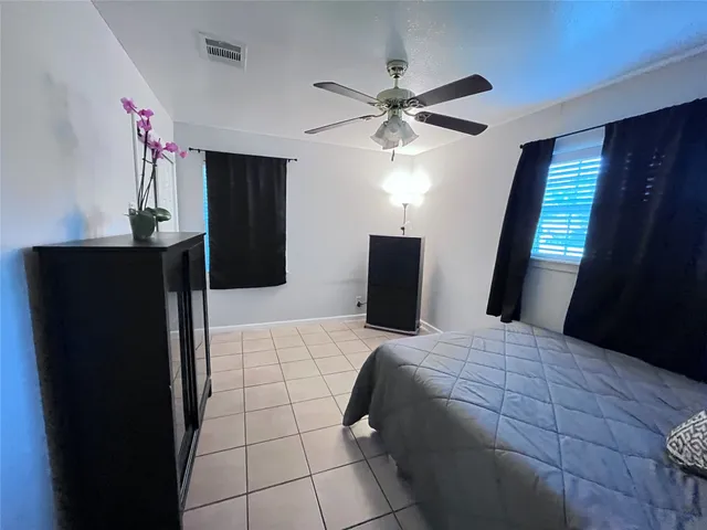 a bedroom with a large bed and a flat tv screen on dresser