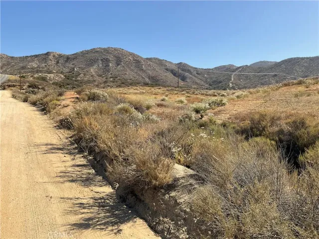 a view of a dry yard with mountains in the background