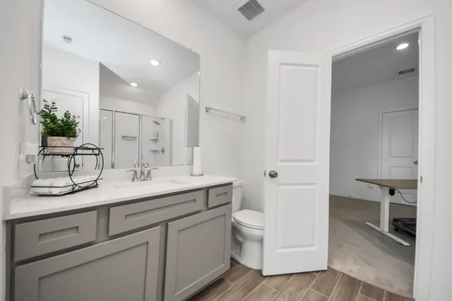 a bathroom with a granite countertop sink a toilet and a mirror