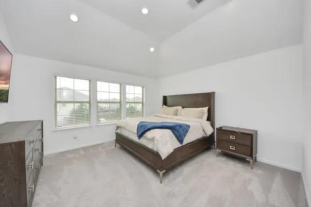 a spacious bedroom with a bed and a large window