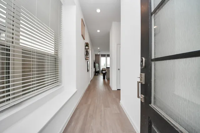 a view of a hallway with wooden floor and staircase