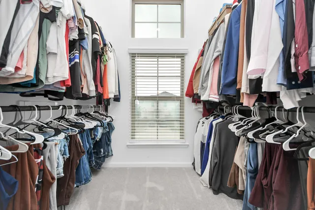 a view of walk in closet with clothes and shoes