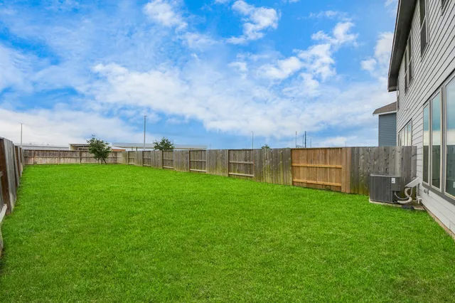 a view of a green field with wooden fence