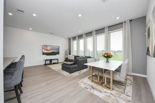 a living room with furniture a flat screen tv and a large window