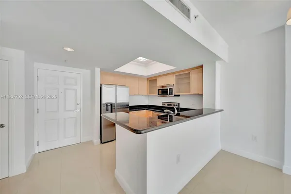 a kitchen with stainless steel appliances granite countertop a sink a stove and a refrigerator