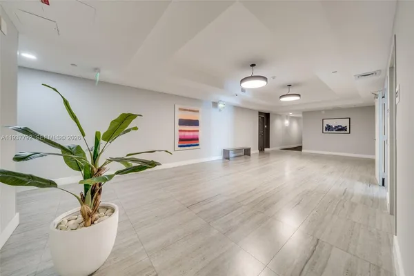 a view of a hallway with wooden floor and a potted plant