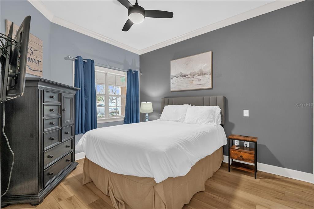 1362 Centre Ct Ridge Drive, Unit 102 Reunion, FL 34747 - Photo 15 of 35 a bedroom with a bed and a flat tv screen on dresser