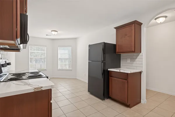 a kitchen with stainless steel appliances granite countertop a refrigerator and a stove