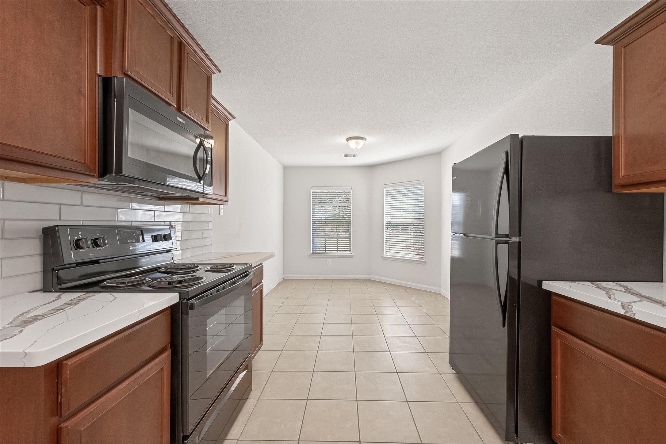 4918 Jagged Cliff Lane Rosenberg, TX 77469 - Photo 7 of 23 a kitchen with stainless steel appliances granite countertop a sink stove and refrigerator