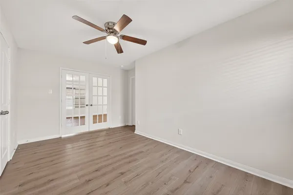 a view of an empty room with window and wooden floor