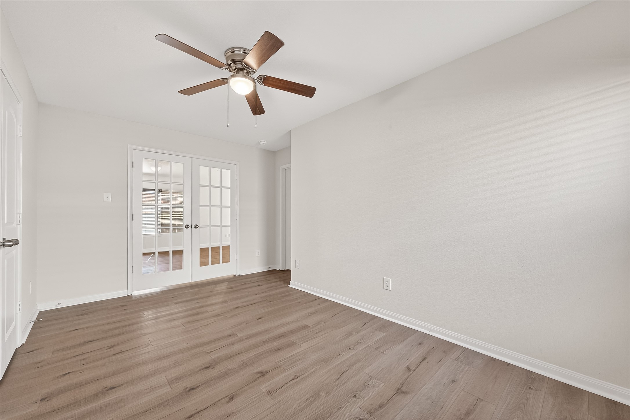 4918 Jagged Cliff Lane Rosenberg, TX 77469 - Photo 9 of 23 a view of an empty room with window and wooden floor