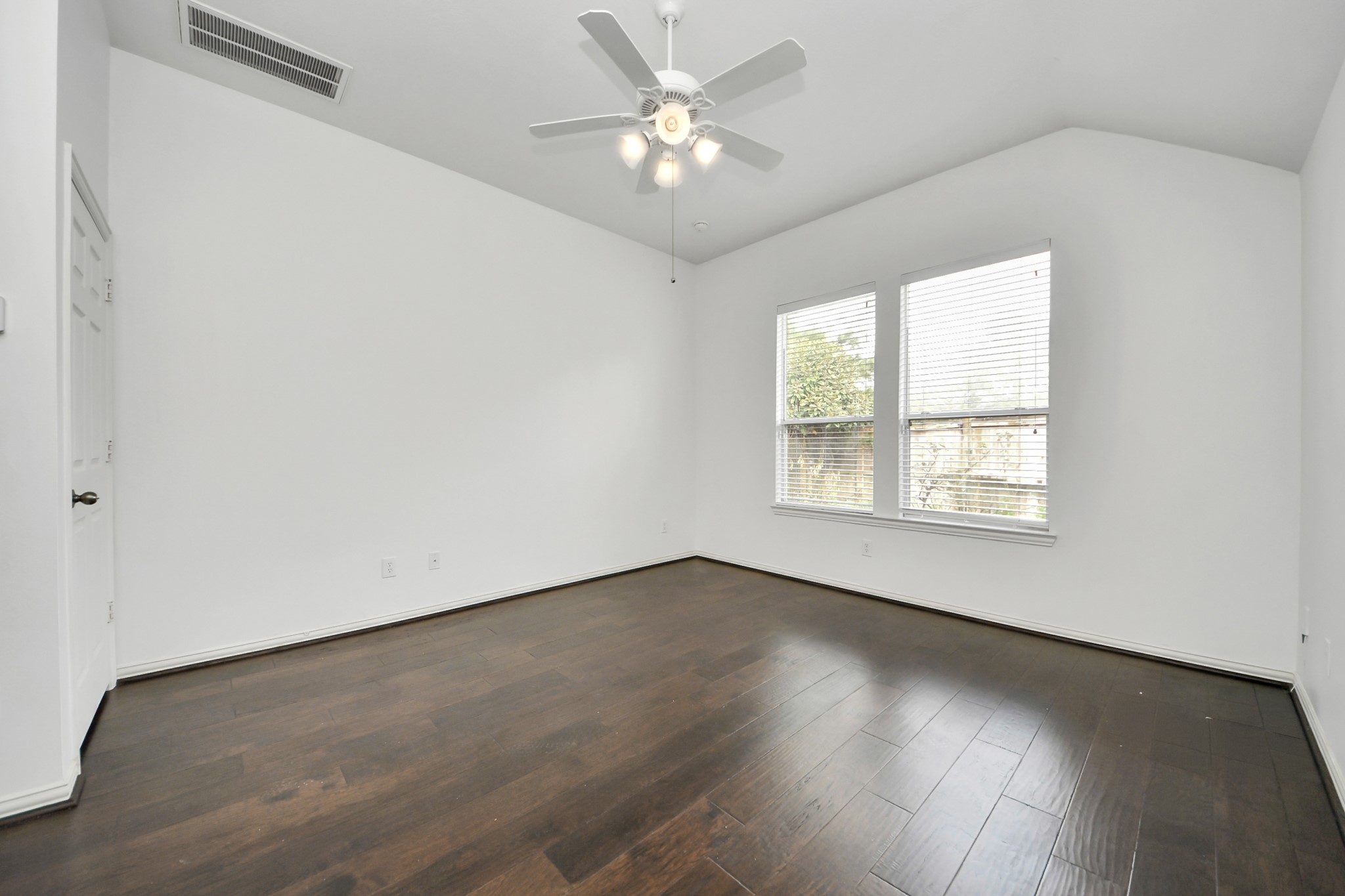 2907 Bright Sky Court Spring, TX 77386 - Photo 14 of 27 an empty room with wooden floor chandelier fan and windows