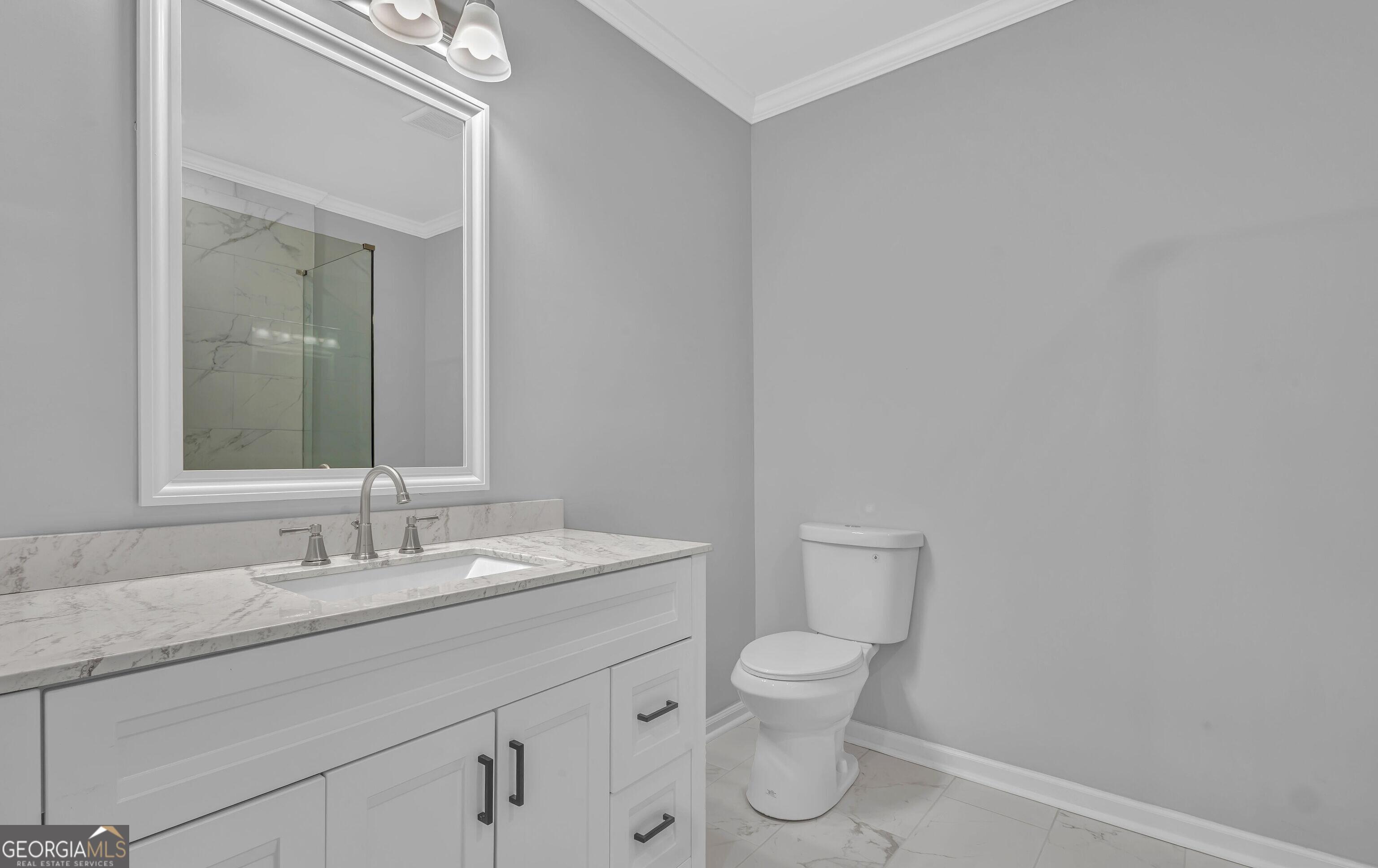 1080 Westmont Road Southwest Atlanta, GA 30310 - Photo 11 of 15 a bathroom with a granite countertop toilet sink and mirror