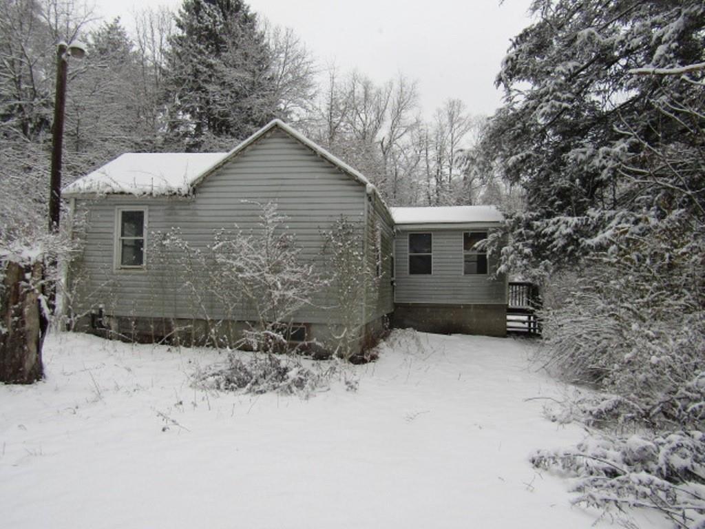 front view of a house with a yard covered in snow