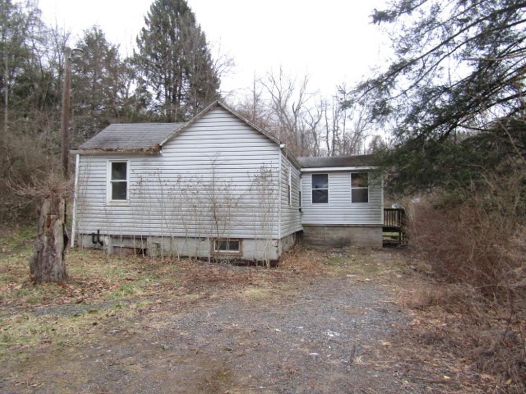 a view of a house with a yard and wooden fence