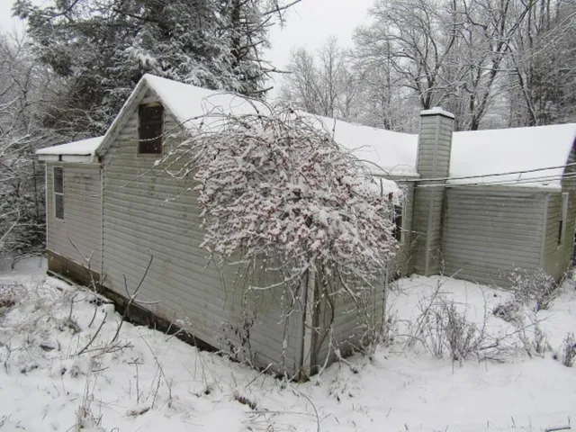 a view of a house with a yard covered in snow