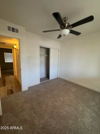 an empty room with a window and a fan