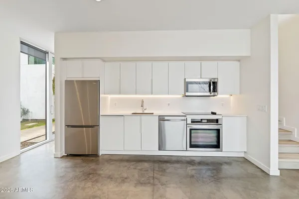 a kitchen with stainless steel appliances granite countertop a refrigerator and a stove top oven