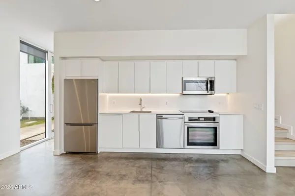 a kitchen with stainless steel appliances granite countertop a refrigerator and a stove top oven