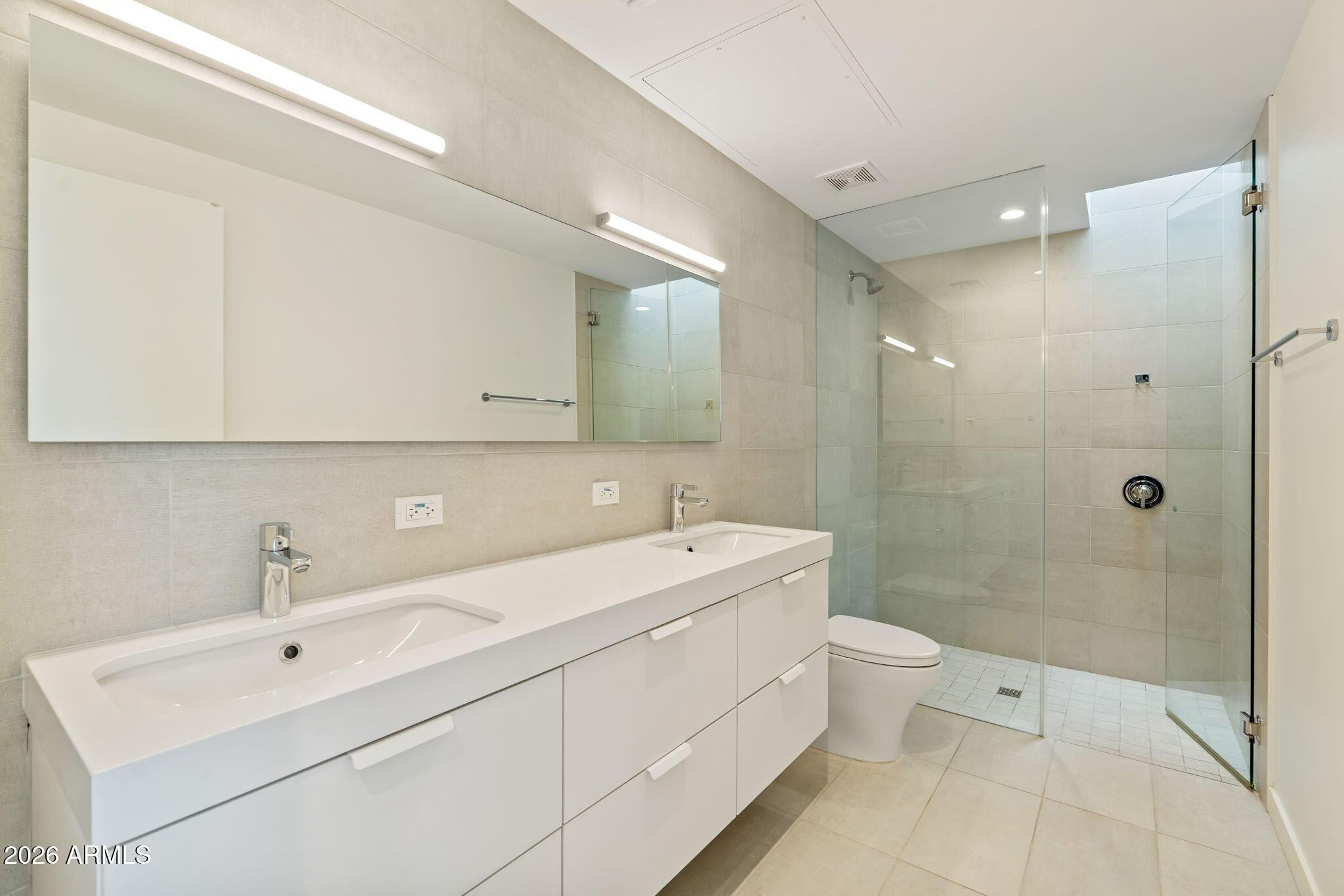 1337 East Polk Street, Unit 7 Phoenix, AZ 85006 - Photo 4 of 25 a spacious bathroom with a double vanity sink toilet mirror and shower