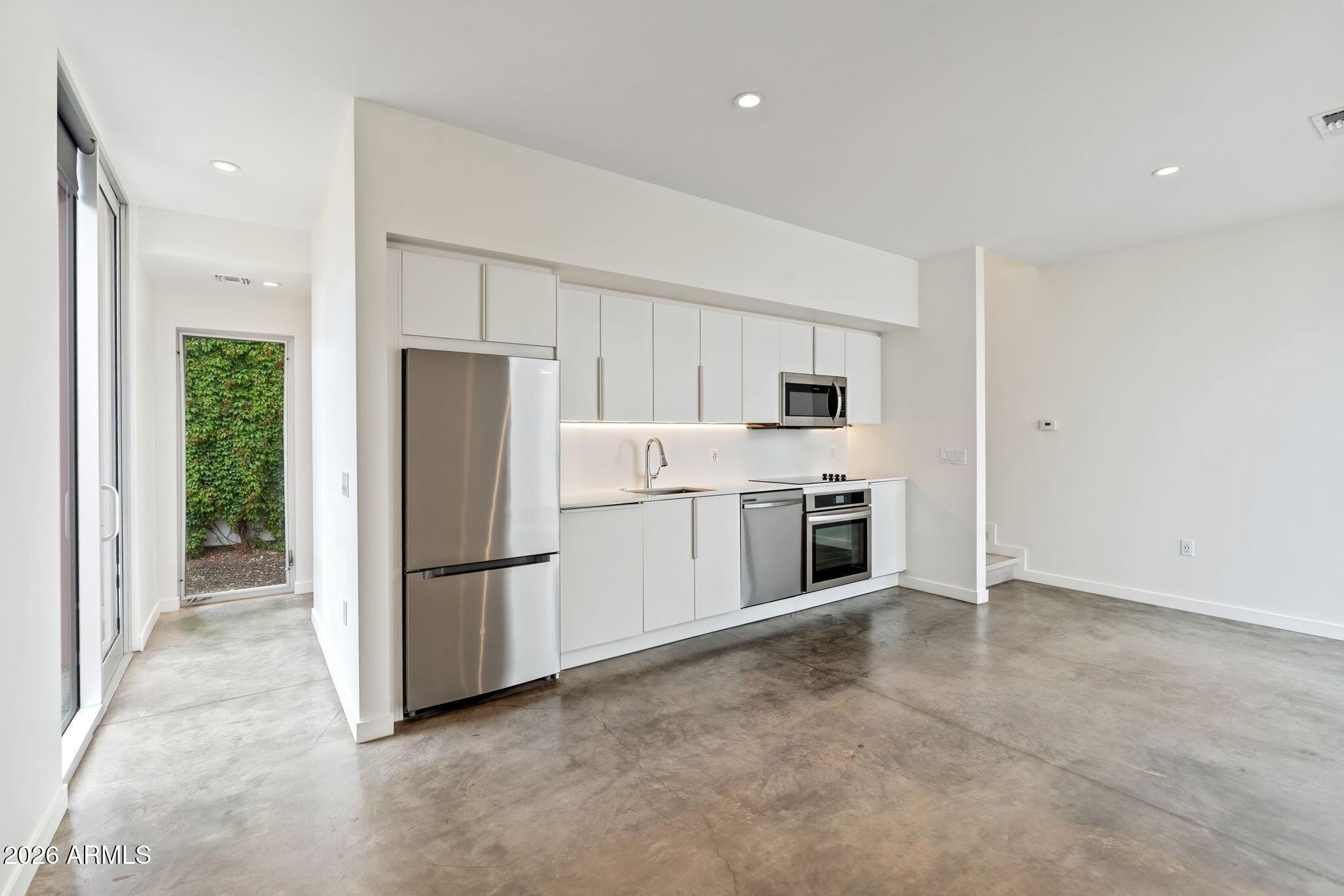 1337 East Polk Street, Unit 7 Phoenix, AZ 85006 - Photo 9 of 25 a kitchen with stainless steel appliances a refrigerator and a stove top oven