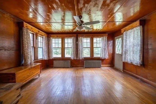 an empty room with windows and fan