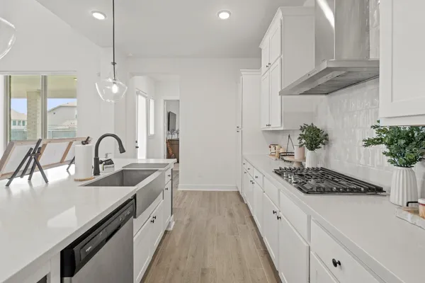 a kitchen with stainless steel appliances granite countertop a sink a stove and a wooden floors