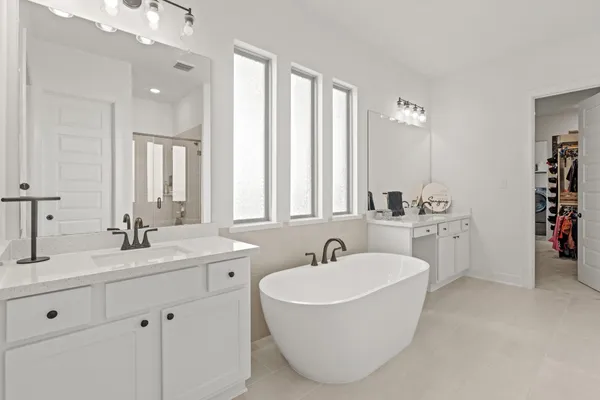 a bathroom with a double vanity sink a mirror and a bathtub