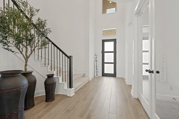 a view of a hallway with wooden floor and staircase