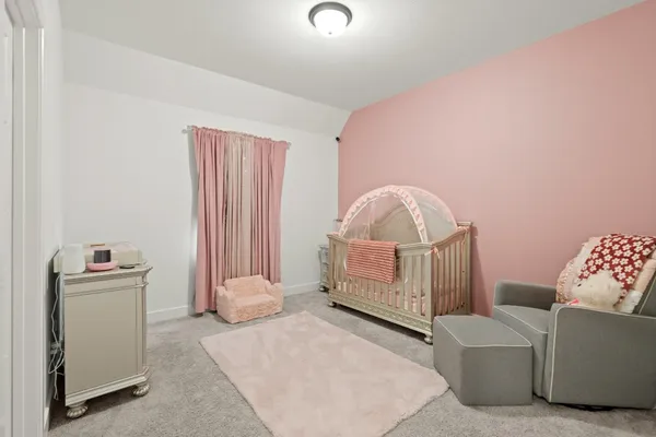 a living room with furniture and a baby crib
