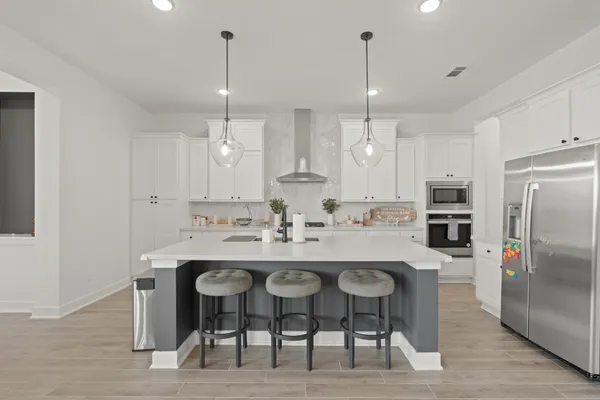 a kitchen with refrigerator and chairs