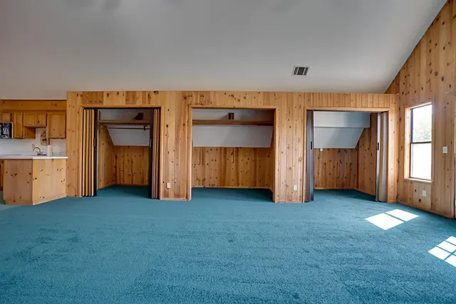 a view of an empty room with closet and cabinet