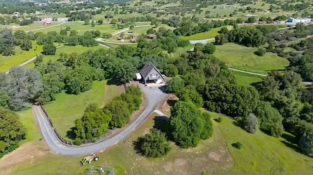 an aerial view of a residential houses with yard