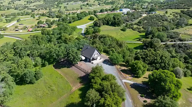 an aerial view of a house with a yard and lake view
