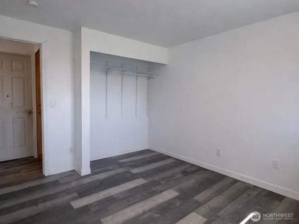an empty room with wooden floor and closet