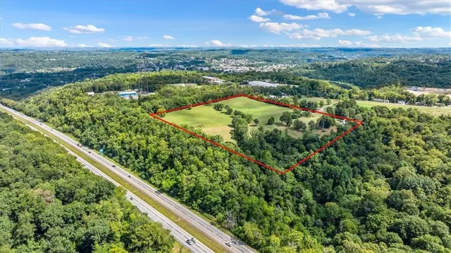 an aerial view of residential houses with outdoor space and trees