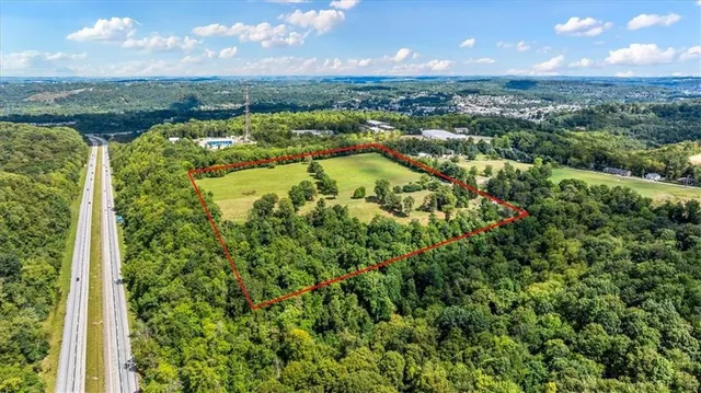 an aerial view of residential houses with outdoor space and trees